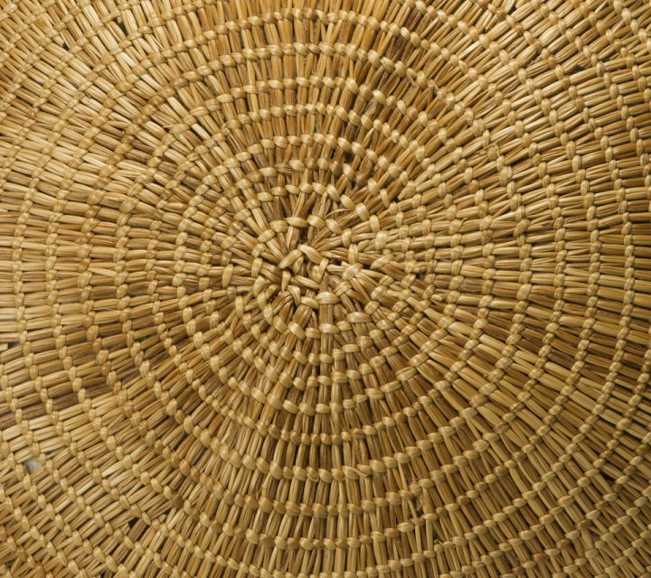 base of a large grass basket with a circular weaving pattern.